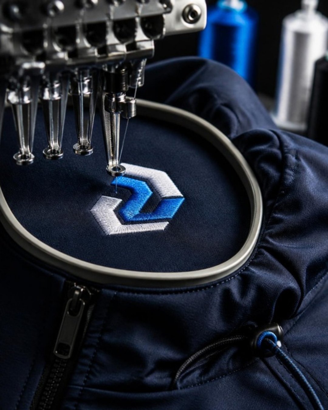 Máquina bordadora bordando un logo corporativo en una chaqueta de trabajo